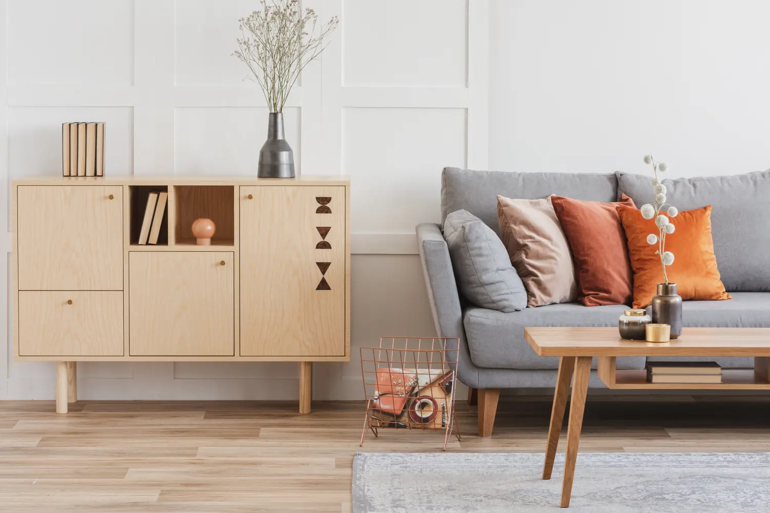 Holzmöbel und graues skandinavisches Sofa mit Kissen in wunderschönem Wohnzimmerinterieur